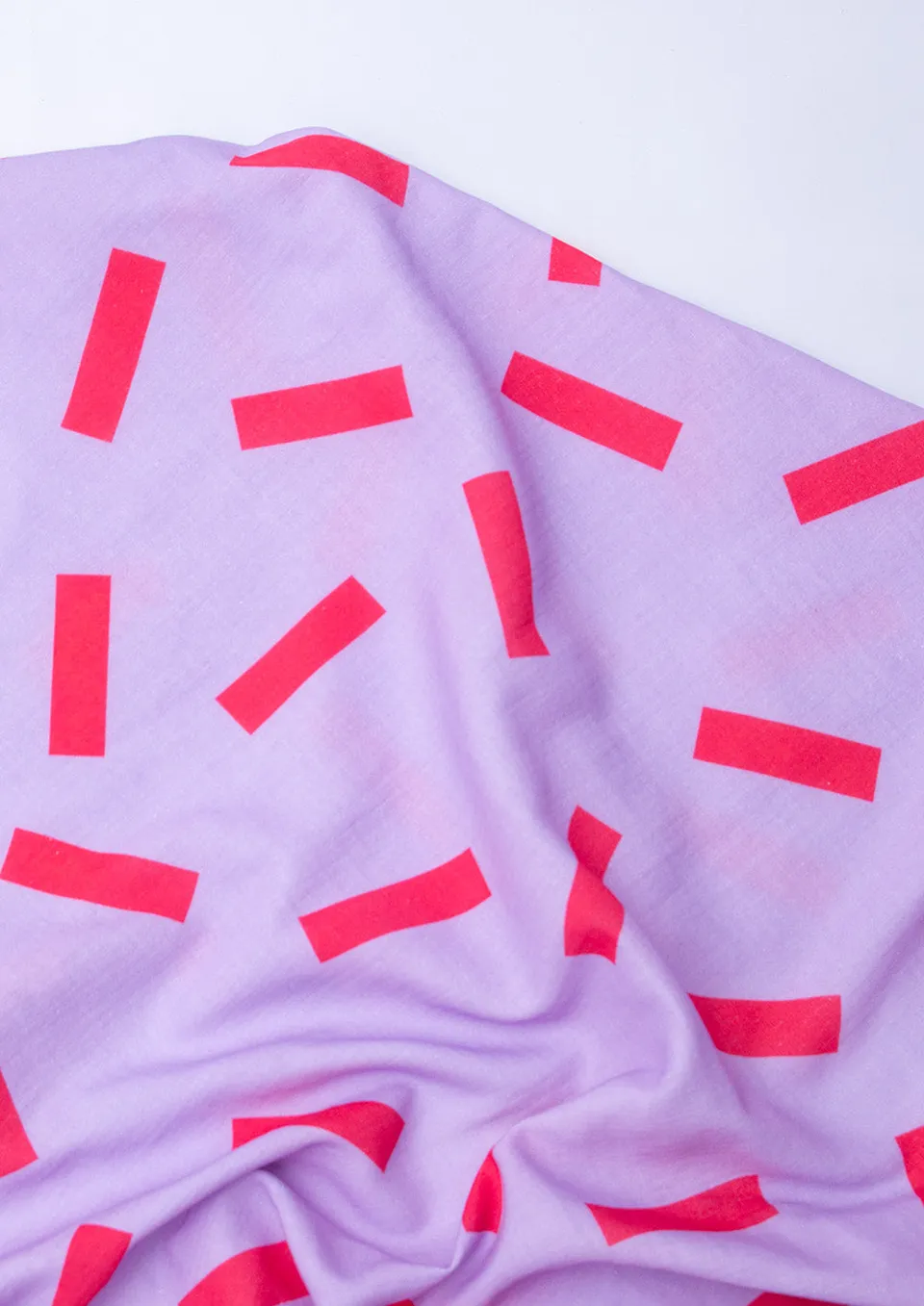 konfetti-patterns-musselin-striche-rot-auf-lilac-meterware image 1